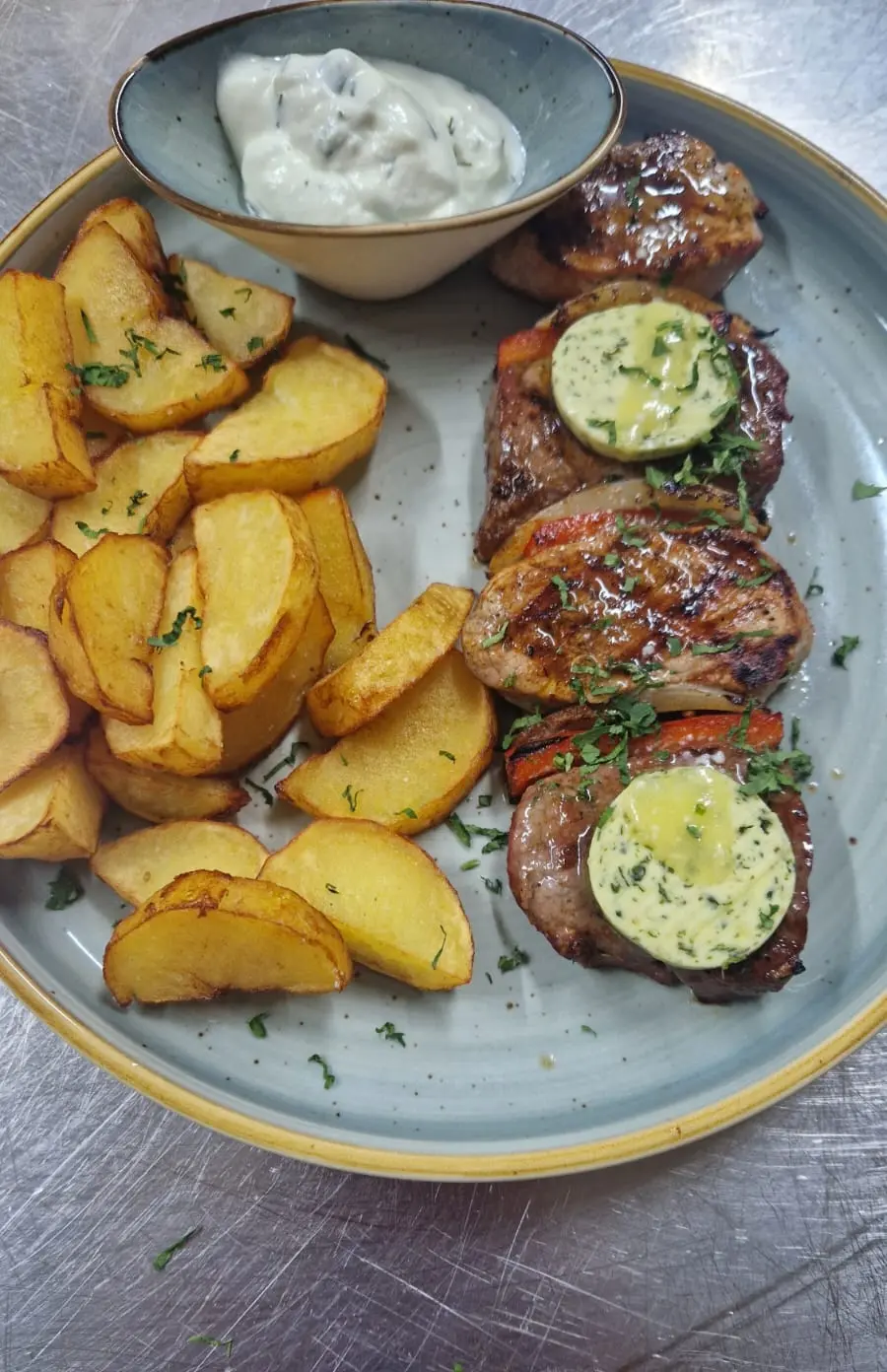 Gegrillter Grillteller mit Tzatziki, Pommes und Zitrone